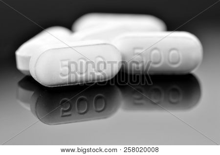 White Caplet With Reflection On Dark Background. Paracetamol 500 Mg. Tablet The Otc Medicine For Rel