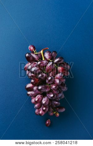 Bunch Of Red Ripe Grape On Dark Blue Background. Top View.