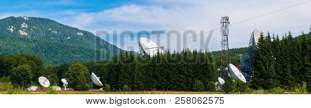 Big Satellite Dish Antennas Hidden In Green Pine Tree Forest. Satellite Communication Center In Chei