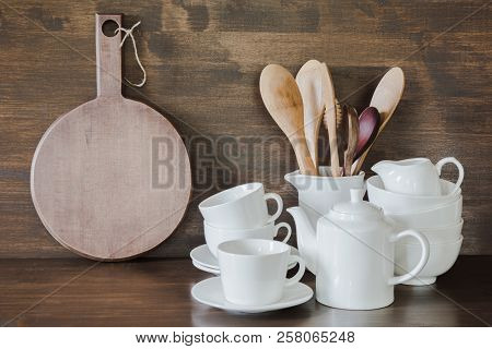Crockery, Clayware, White Utensils And Other Different Stuff On Wooden Tabletop. Kitchen Still Life 