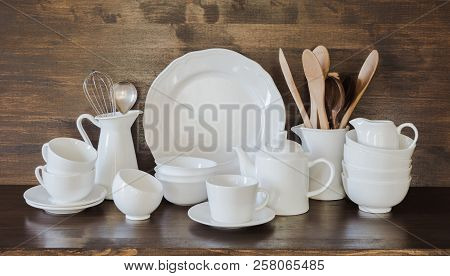 Crockery, Clayware, White Utensils And Other Different Stuff On Wooden Tabletop. Kitchen Still Life 