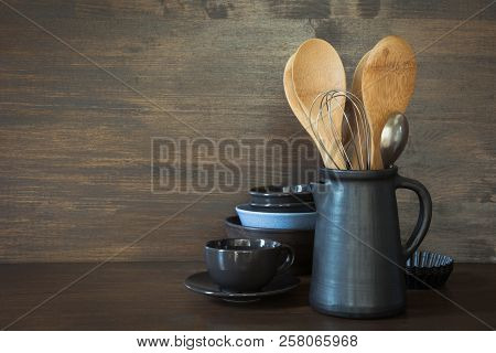 Crockery, Clayware, Dark Utensils And Other Different Stuff On Wooden Tabletop. Kitchen Still Life A