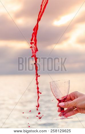 Girl Holding A Glass With Wine Uring The Sunset On The Sea