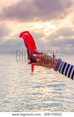 Girl Holding A Glass With Wine Uring The Sunset On The Sea