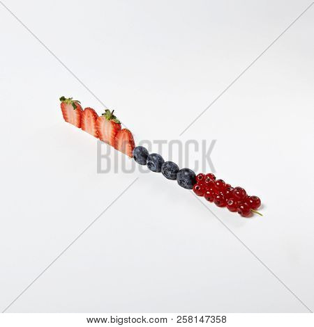 Macro Photo of Healthy Fresh Berries Breakfast Components or Food Ingredients Concept Isolated. Minimal Creative Layout with Organic Strowberries, Blueberries, Raspberries Lined Up in a Diagonal Row