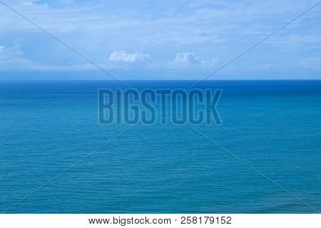 Sea Turquoise Color And Blue Sky With White Clouds.