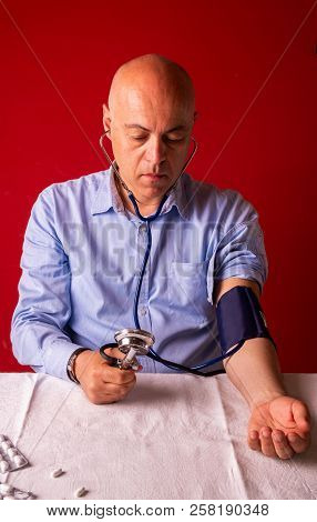 Hypertensive Patient Performing A Blood Pressure Auto Test / Man Self-monitoring Of Blood Pressure W