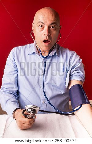 Hypertensive Patient Performing A Blood Pressure Auto Test / Man Self-monitoring Of Blood Pressure W