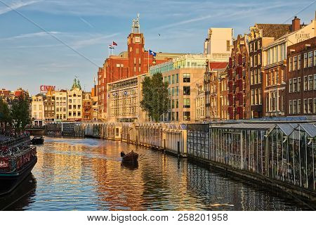 Beautiful View Of Amsterdam Canals With Bridge And Typical Dutch Houses