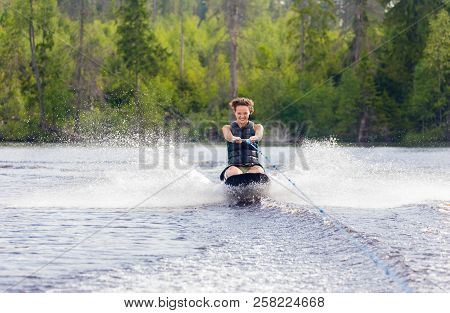 Young Athletic Woman Riding Kneeboard On A Lake
