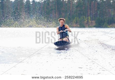 Young Athletic Woman Riding Kneeboard On A Lake