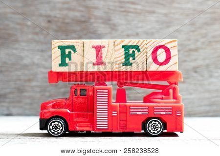 Toy Fire Ladder Truck Hold Letter Block In Word Fifo (abbreviation Of First In First Out) On Wood Ba
