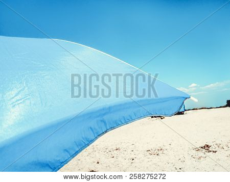 Sun Beach Umbrella Parasol On Sunny Day On Background Of A Blue Sky Giving Shade And Protection.