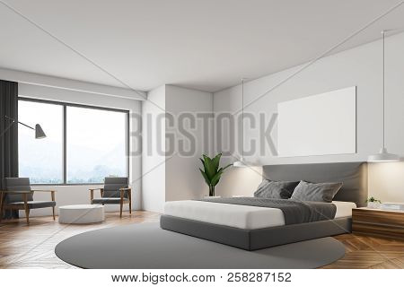 White Minimalistic Bedroom With Wooden Floor, Round Carpet With Masterbed On It, Night Stand And Rou