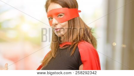 Middle age super hero woman wearing red mask and cape confident and happy with a big natural smile inviting to enter