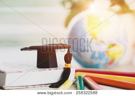 Graduate Or Education Knowledge Learning Study Abroad Concept : Graduation Cap On Book With Blur Of 