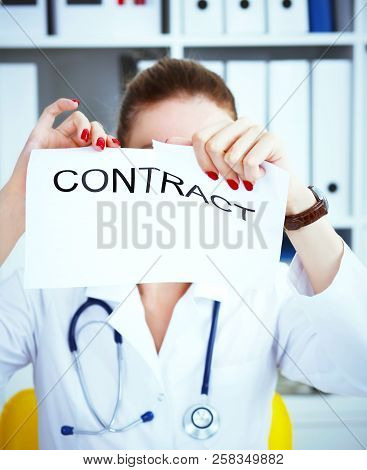 Hands Of Female Medicine Doctor Ripping Contract. Photo With Depth Of Field.
