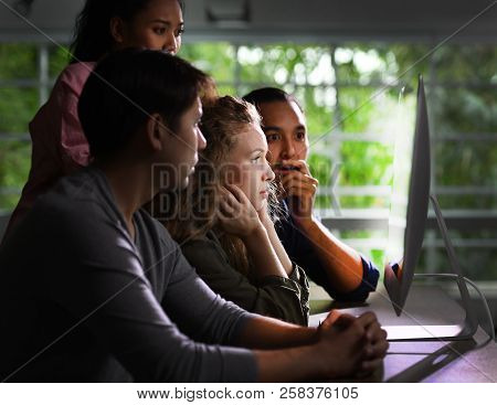 Group Of Young Businesspersons Looking Intently At The Screen With Shock Anxious And Worried Express