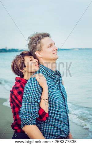 Portraits Of Romantic Couple On The Sea Beach Embracing Each Other. Concept Of Lovers Happy Moments 
