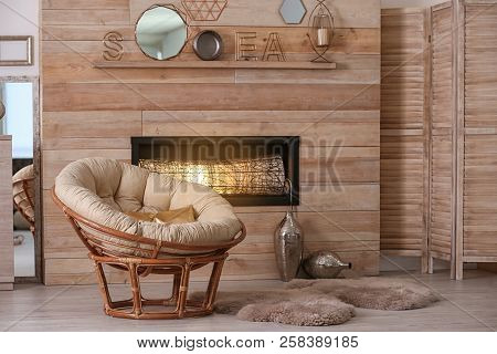 Cozy Living Room Interior With Comfortable Papasan Chair And Decorative Fireplace