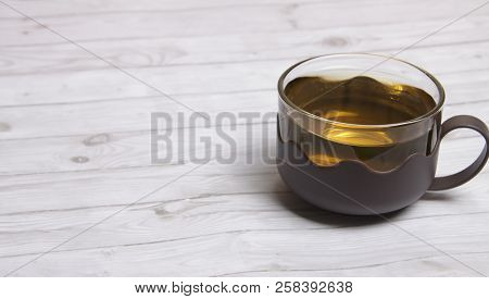 A Cup Of Green Tea With On White Wooden Table