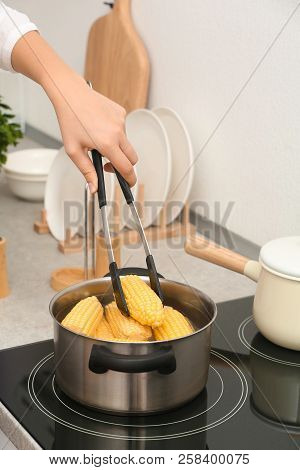 Woman Preparing Corn In Stewpot On Stove, Closeup