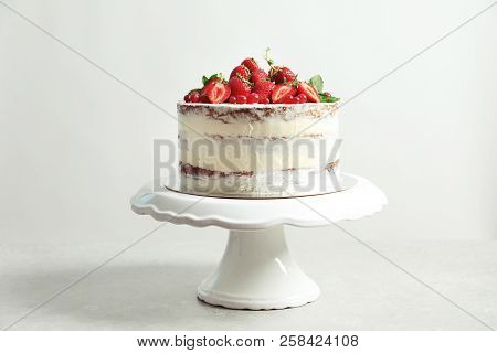 Delicious Homemade Cake With Fresh Berries On Stand Against Light Background
