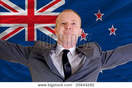 Happy Businessman Because Of Profitable Investment In New Zealand Standing Near Flag