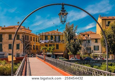 View Towards The Medieval Town Of Vintimiglia From The Bridge Above The River Roya In Italy Across F