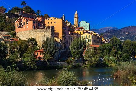 Colorful Old Buildings Perched Atop A Hill In The Medieval Town Of Vintimiglia In Italy, Just Across