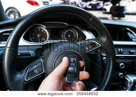 Man's Hand Holding A Wireless Car Key In Black Leather Interior. Modern Car Interior Details. Car De
