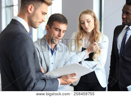 Young Modern Colleagues In Smart Casual Wear Having A Brainstorm Meeting While Standing In The Creat