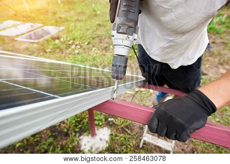 Close-up Angled View Of Technician Working With Screwdriver Connecting Solar Photo Voltaic Panel To 
