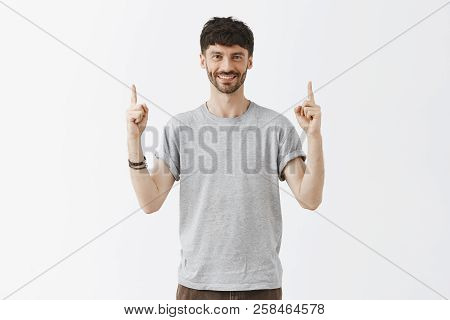 Stylish Carefree And Confident Aduly Bearded Man In Gray Casual T-shirt And Bracelettes Raising Inde