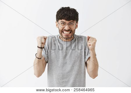 Attractive Bearded Man Clenching Teeth Not To Shout From Rage And Anger Raising Fists And Staring An