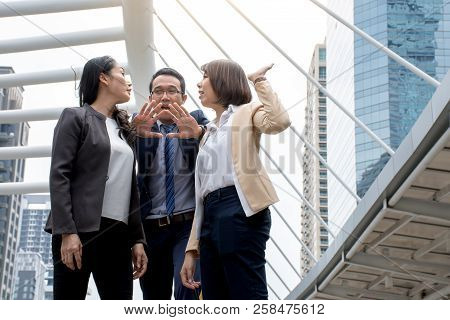 Portrait Of Aggressive Young Asian Women In Formal Wear Or Businesswoman Fighting While Man Dissuade