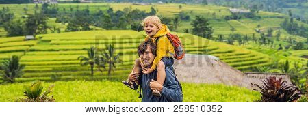 Dad And Son Travelers On Beautiful Jatiluwih Rice Terraces Against The Background Of Famous Volcanoe