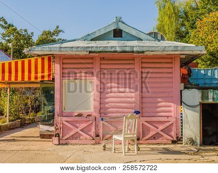 Pink Wooden Building With Yellow And Red Awning And White Roof At Bankrupt Amusement Park,
