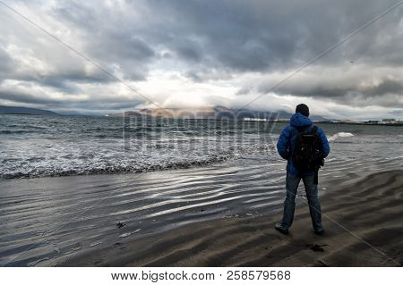 Man Looks On Horizon With Reykjavik Seascape In Iceland. Future Goals Concept. Nature Lovers. Travel