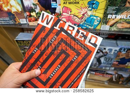 Miami, Usa - August 22, 2018: Wired Magazine In A Hand Over A Stack Of Magazines. Wired Is A Popular