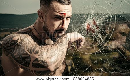 Brutal Man Wiping Blood After Hit. Strong Man Near The Broken Glass. Face With A Scar