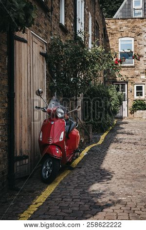 London, Uk - July 17, 2018: Red Vespa Motorbike Parked By A House In Dunworth Mews, Notting Hill. Ho