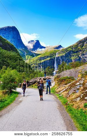 Norway, Olden - August 1, 2018: People At Pathway To Briksdal Or Briksdalsbreen Glacier With Green M