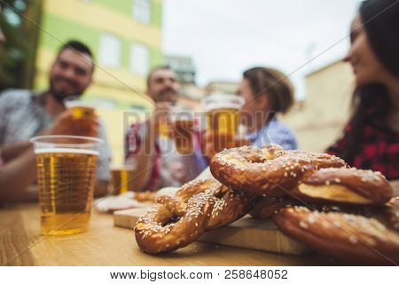 The Group Of Friends Enjoying And Drinking Beer At Outdoor Bar Or Pub. Boiled White Sausages, Served