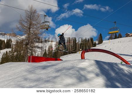Skier In Action: Ski Jumping In The Mountain Snowpark.