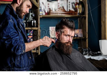 Hipster Lifestyle Concept. Barber With Hair Clipper Works On Hairstyle For Bearded Man Barbershop Ba