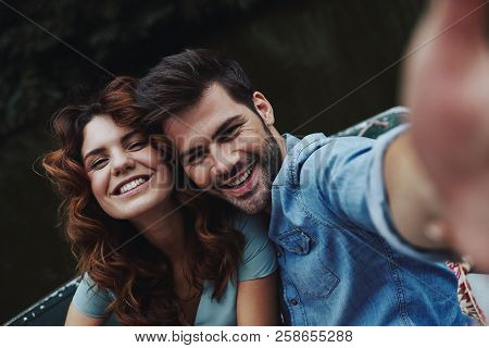 Capturing Happy Moments. Self Portrait Of Beautiful Young Couple Looking At Camera While Sitting In 
