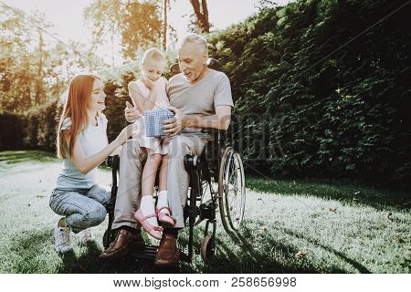 Happy Family On Nature With Child. Family And Caregiver. Child And Old Man. Health Girl With Aged. H