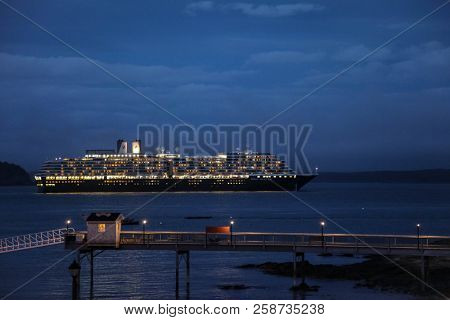 BAR HARBOR, MAINE,USA - OCTOBER 13, 2016.: Bar Harbor with  cruise ship Zuiderdam from Holland American Line  with lights on docking in Frenchman Bay.