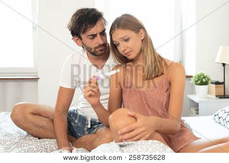 Couple Trying To Have A Baby. Having Problems In Bedroom Concept. Negative Pregnancy Test Result